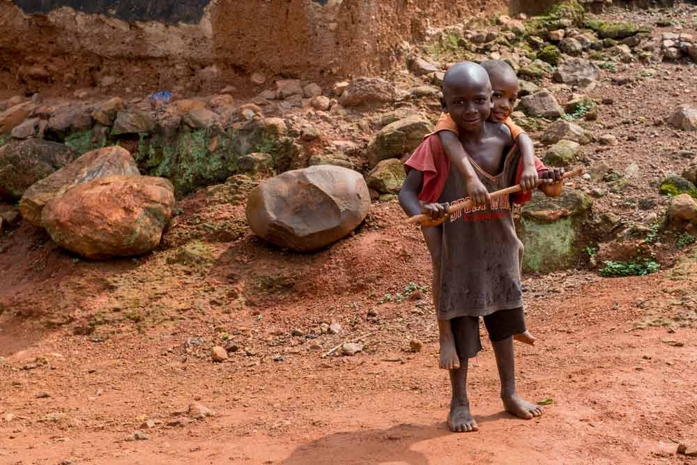 One boy carries another on his back smiling.