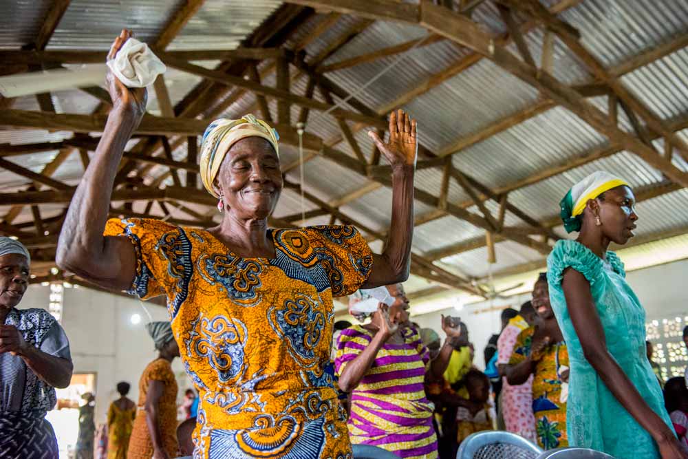 Woman raises her hands worshipping during a church service.
