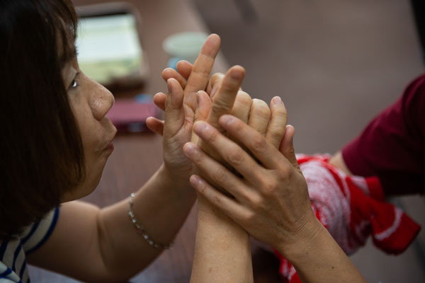 Helping a Deaf and blind woman understand Pastor Matsumoto's sermon.