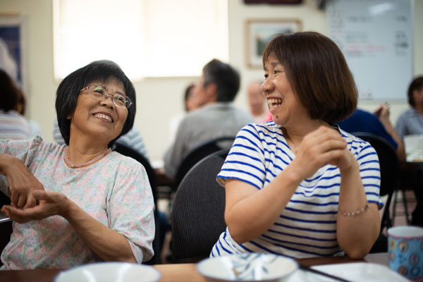 Two Japanese women at a lunch table laughing on Sunday morning.