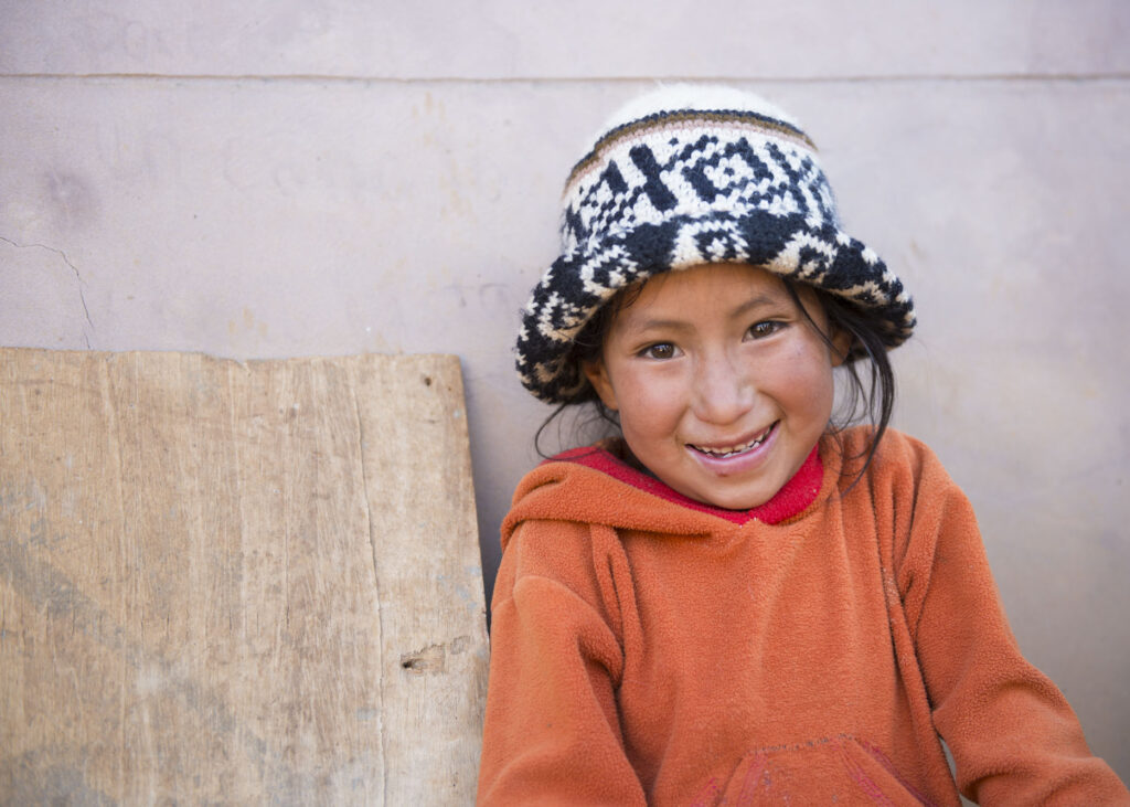 Quechua girl smiles at the camera.