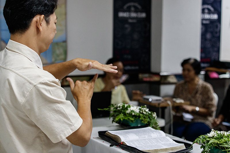 Pastor Montri preaching to congregation