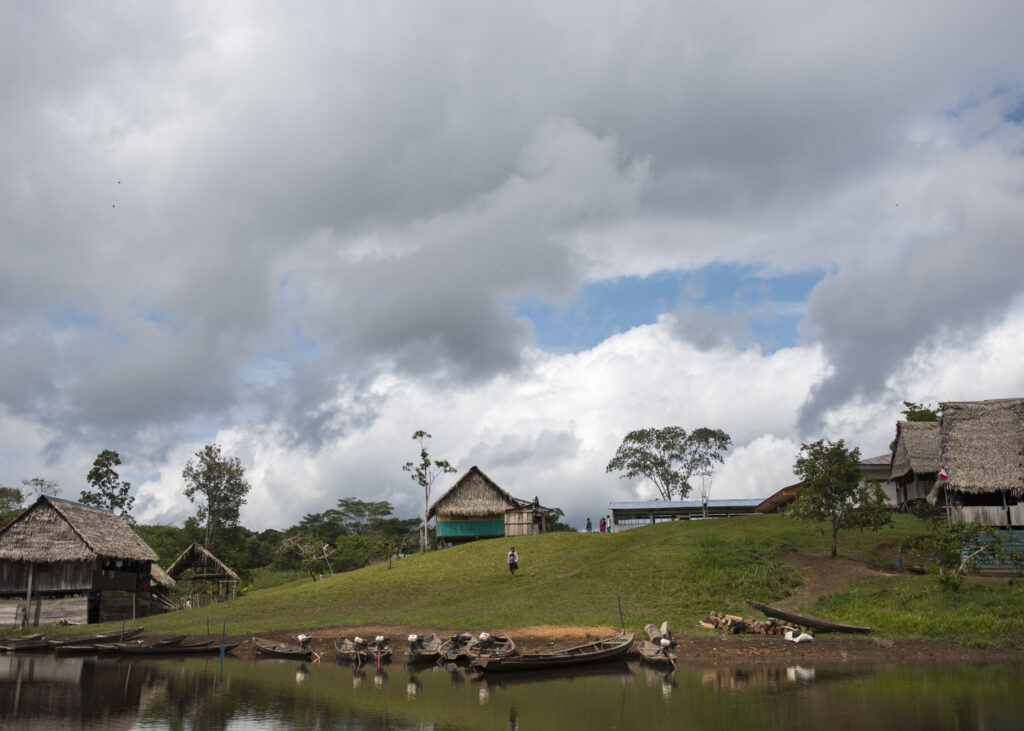 boats parked near a riverside village on a hill