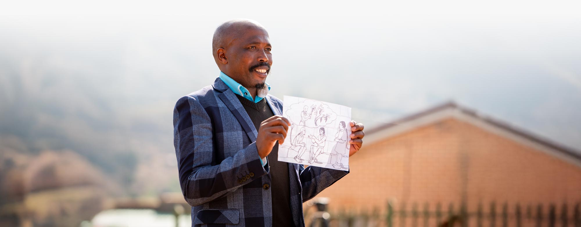 Man in Africa holding a picture with mountains