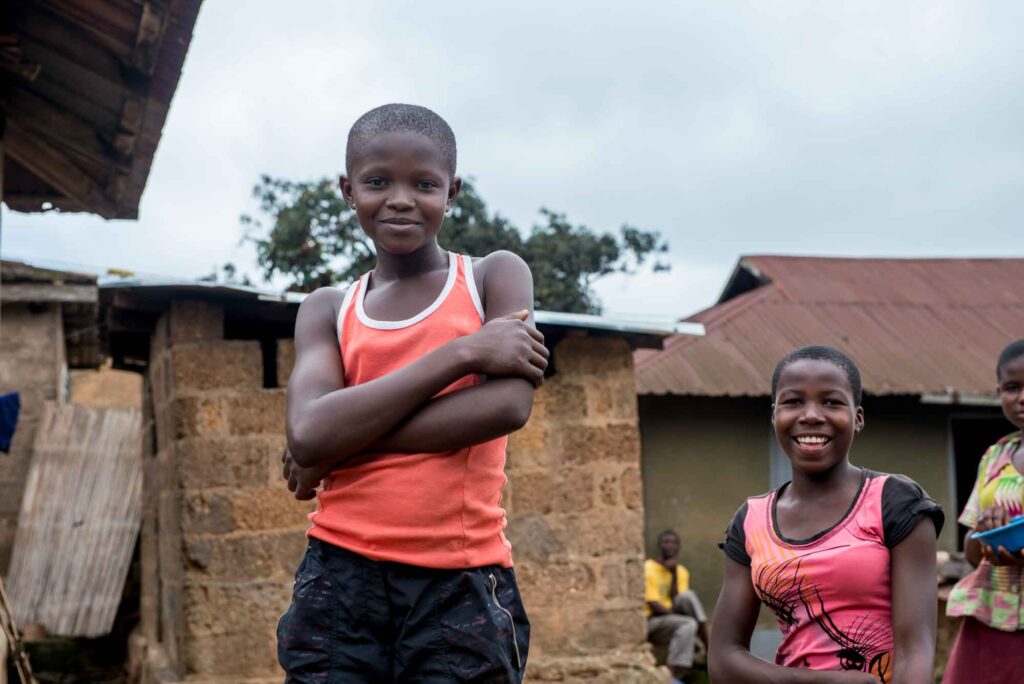 Smiling girls pose for the camera in the village courtyard.