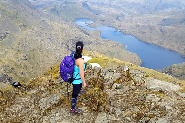 Hiker at the top of a mountain looking out at the summit.