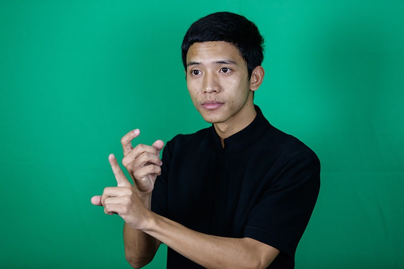 Man signing in Thai sign language.