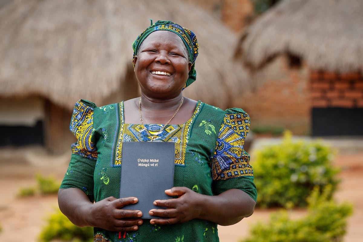 Woman smiling and holding God's Word.