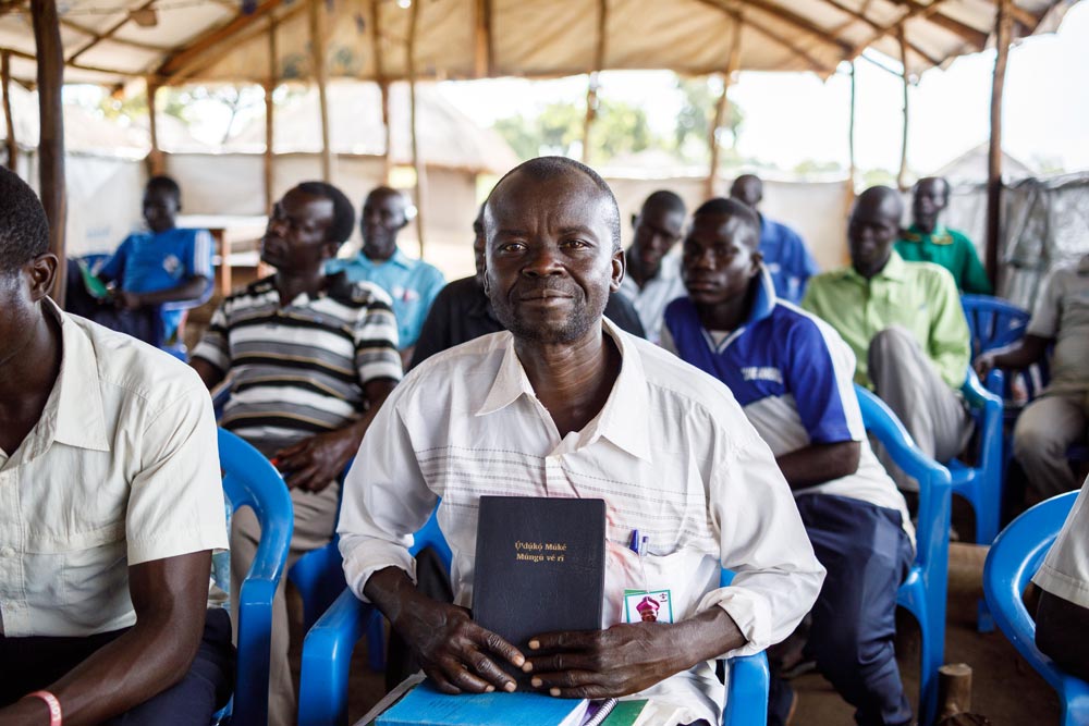 Africa man sitting under a tent with his Bible