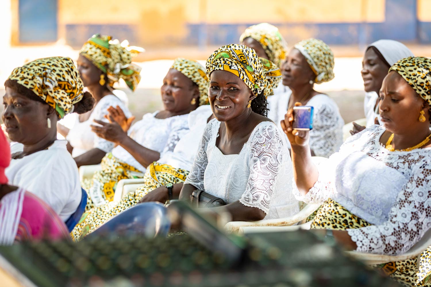 Africa Nigeria group of women seated wearing white lace with colorful scarves