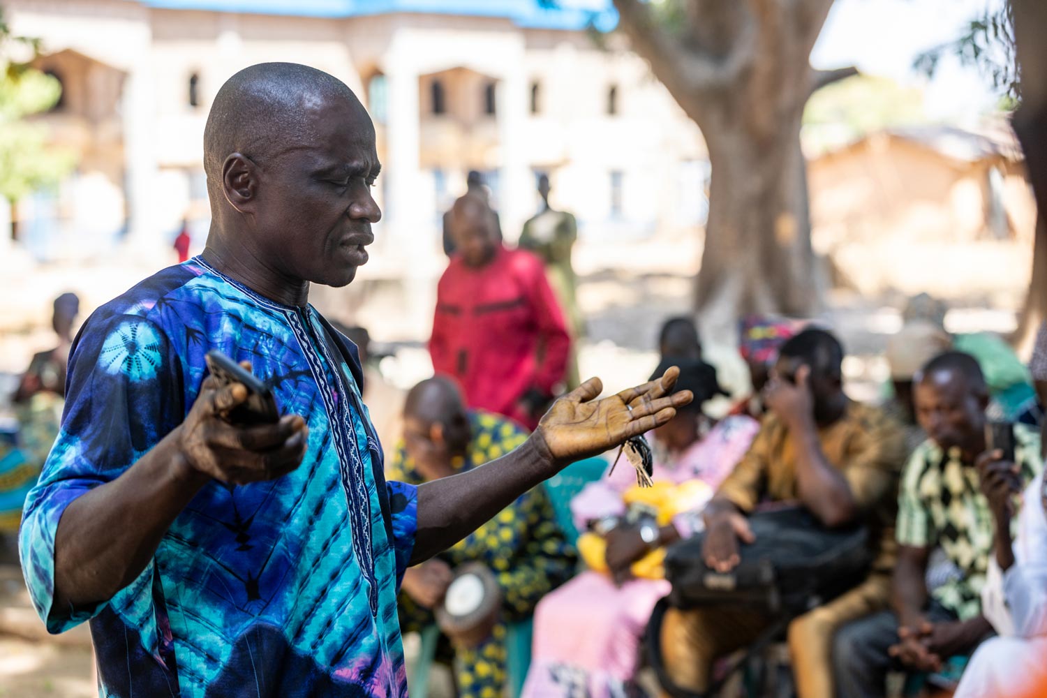 Africa Nigeria man praying with arms raised and others around him praying