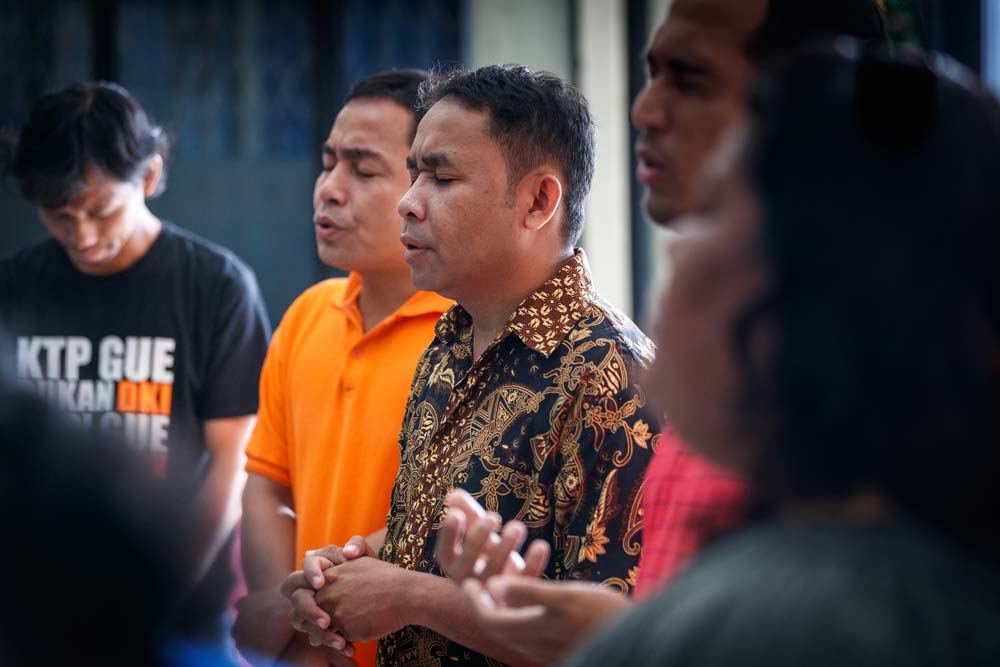 Asia men and women praying together in a group