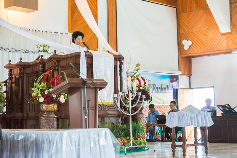 Person preaching from the pulpit in an Indonesian church.