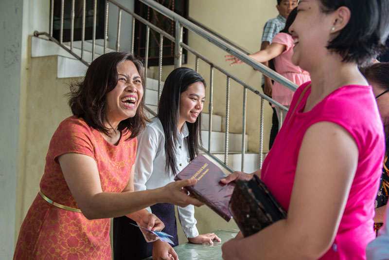 Women joyfully holding the translated New Testament.