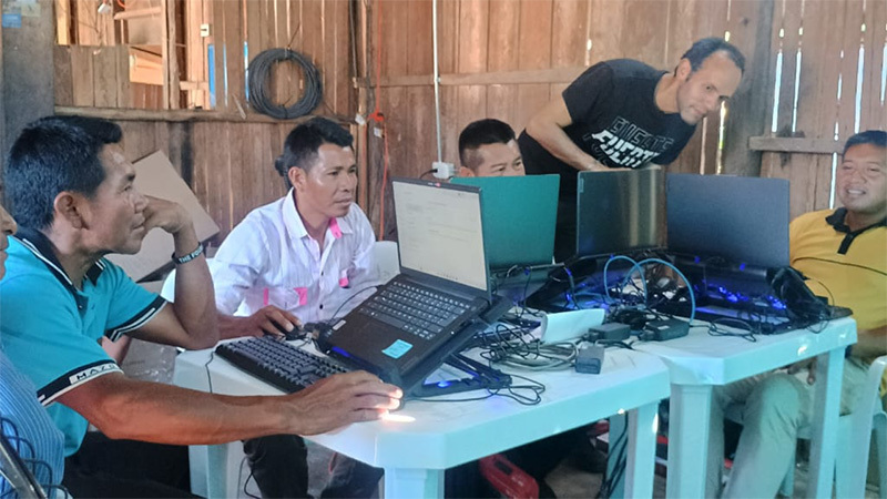 Piapocos translation team working with a special set up to distribute heat from computers.