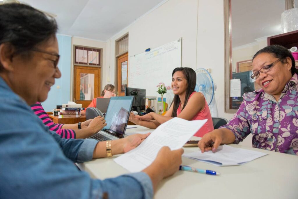 Women collaborating over translation work.
