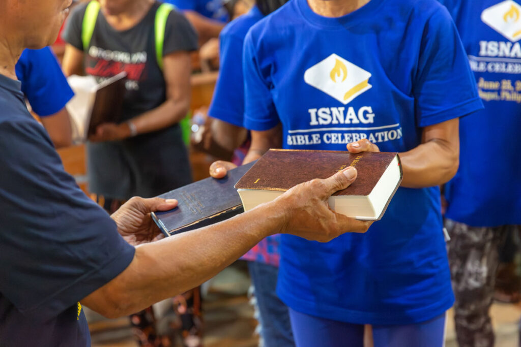 Person exchanging their old Bible for a new one.