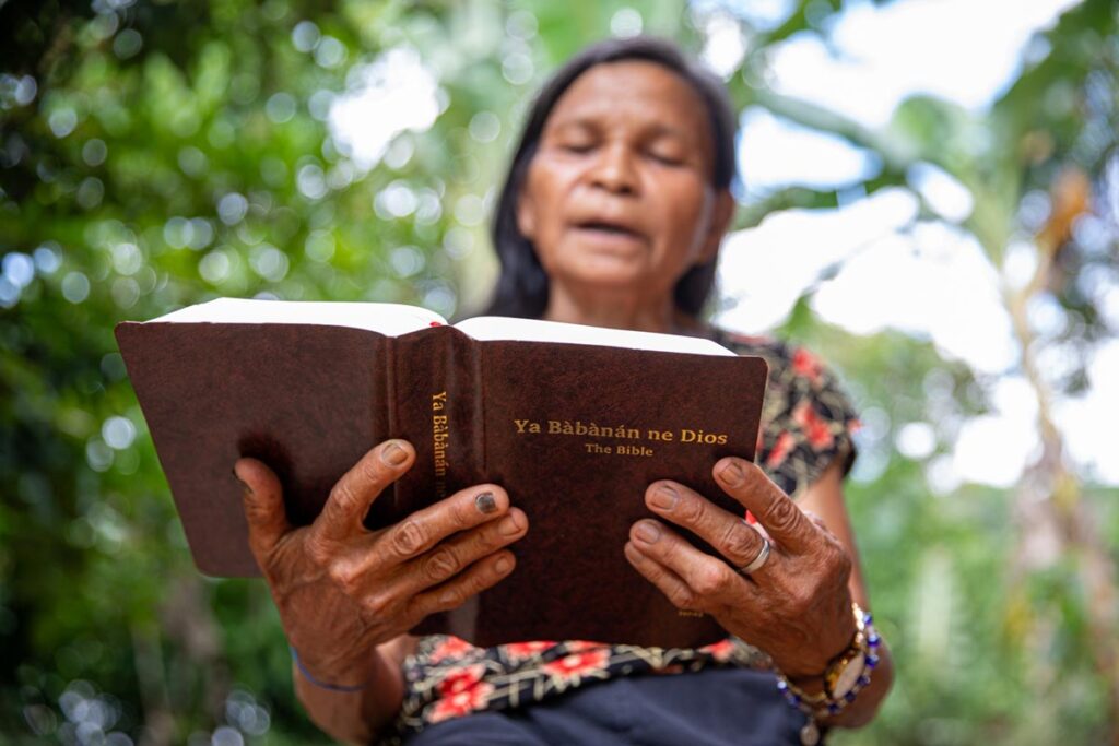 Isnag woman reading from newly translated Bible
