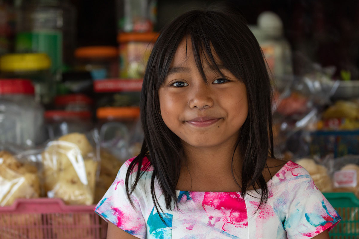 Girl smiling at a market.