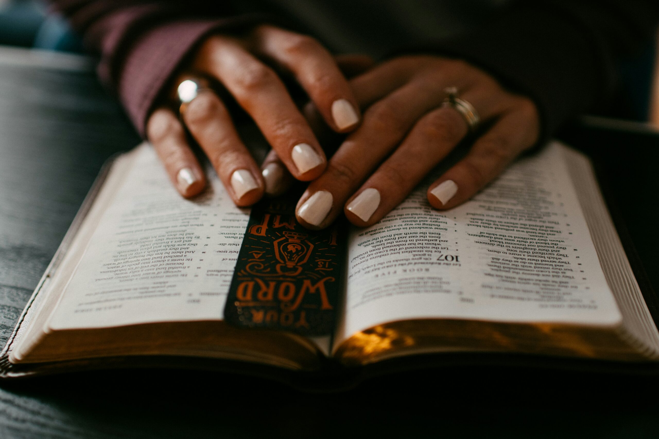 Woman's hands over an open Bible.