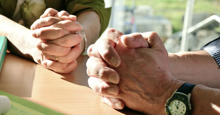 two pairs of hands folded in prayer