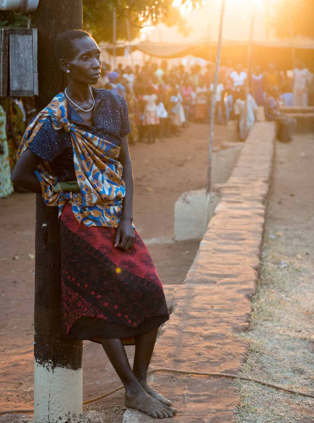 Woman leaning against a pole