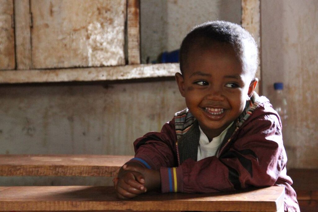 Child sitting at a table and smiling.