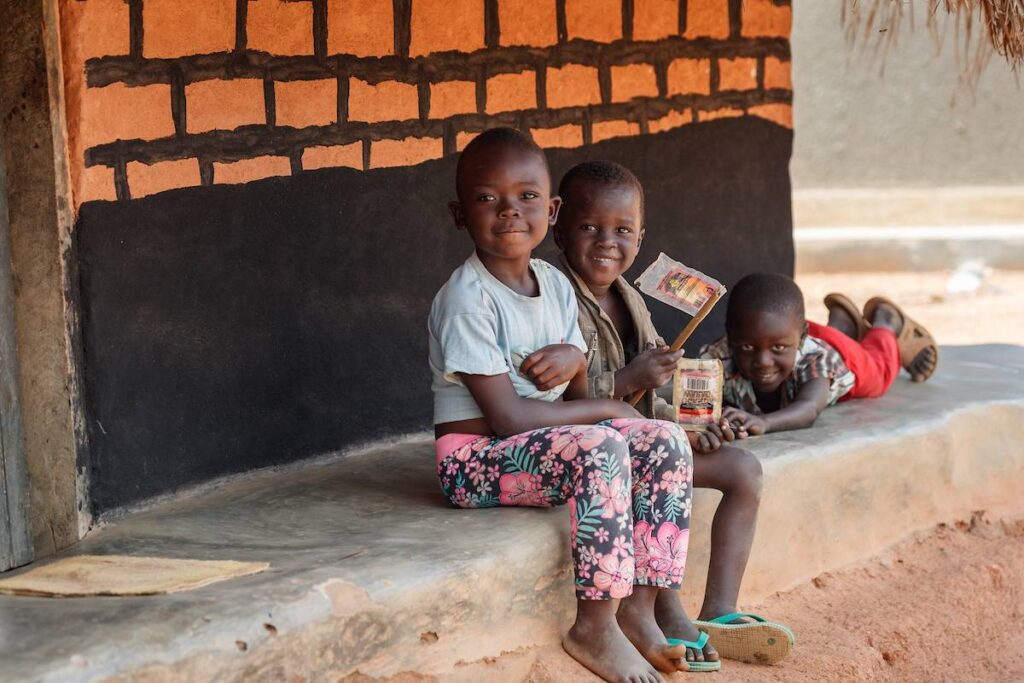 Ugandan kids sitting on a step.