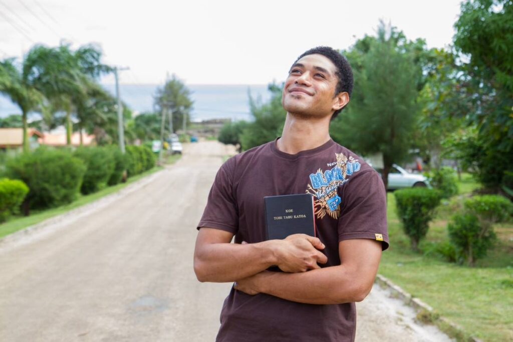 Man from Tonga holding a Bible and looking up. 